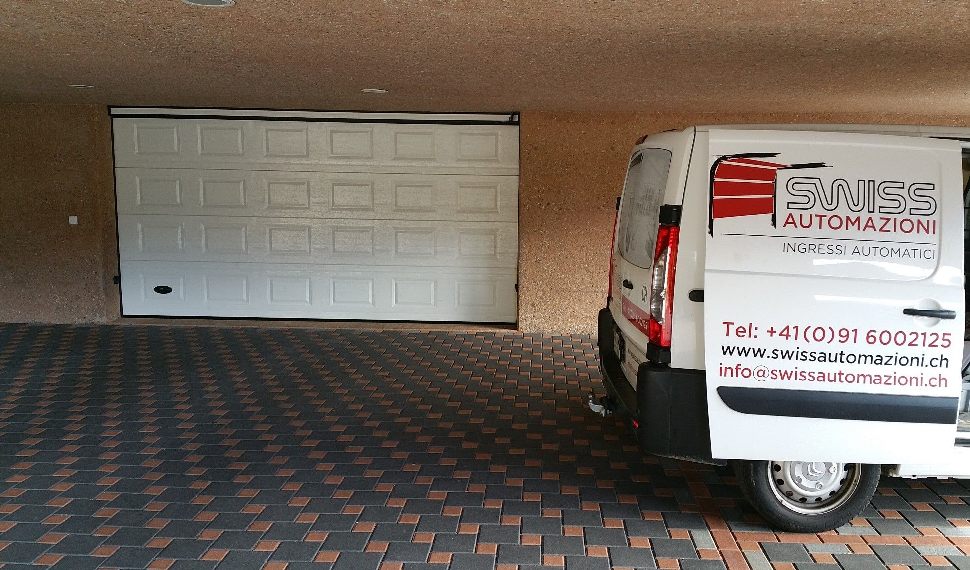 Il furgone di Swiss Automazioni davanti a una porta sezionale bianca
