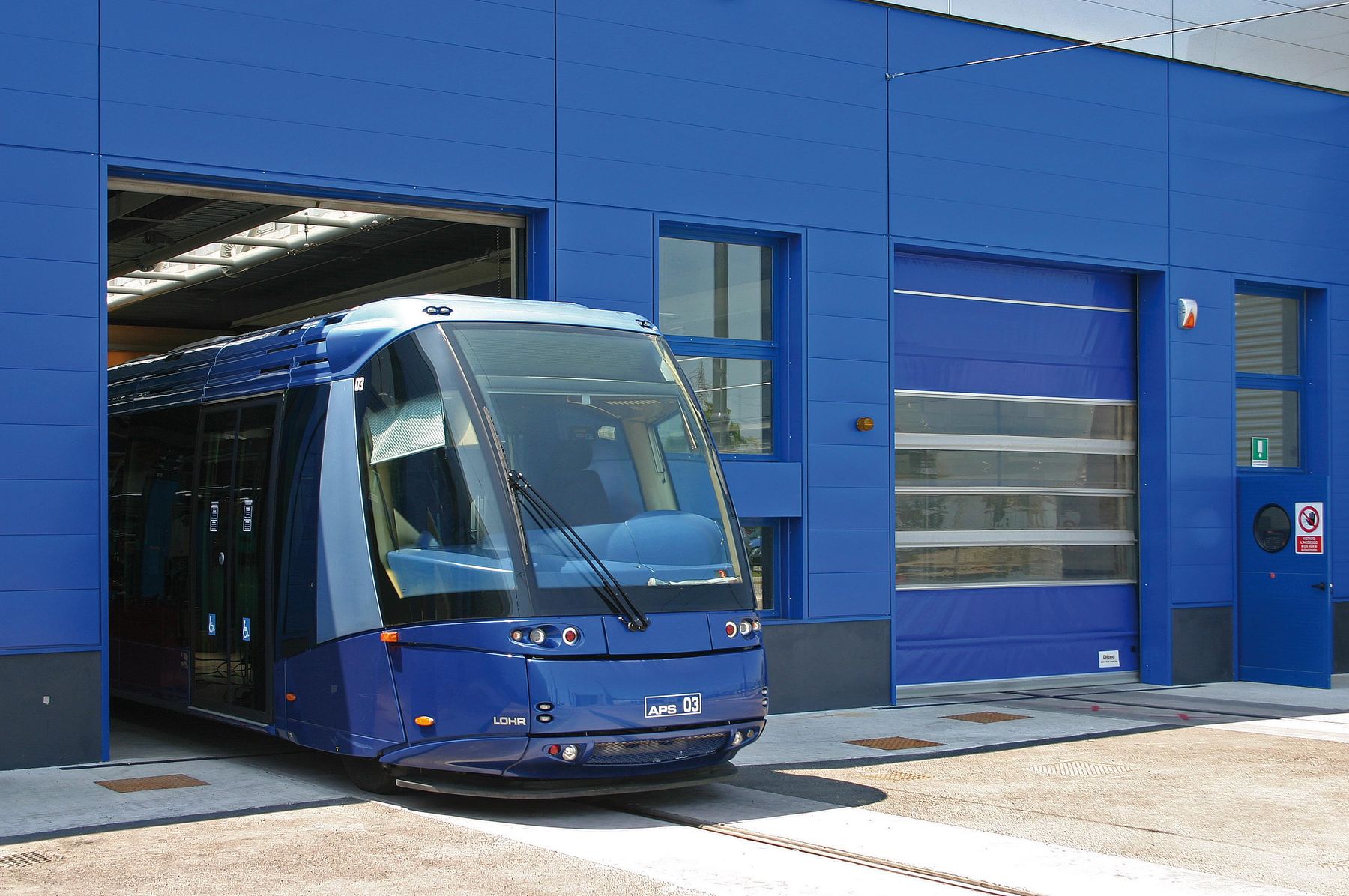 Porte sezionali industriali su una facciata blu
